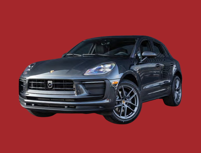 A dark gray Porsche Macan SUV is shown on a solid red background, viewed from the front left corner.
